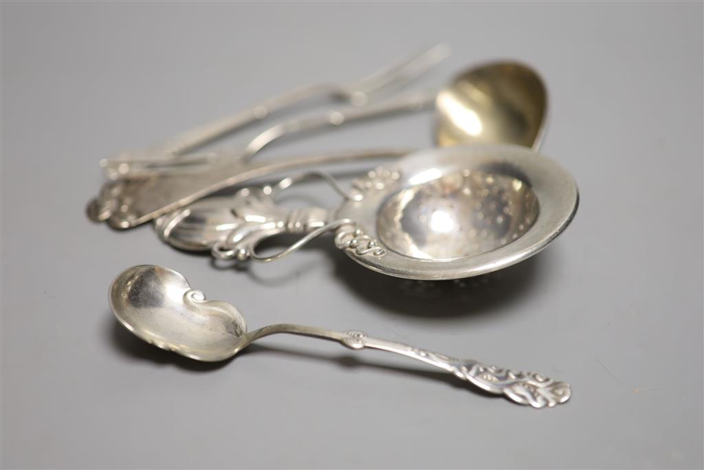 A stylish early 20th century Danish white metal tea strainer, 14.7cm and four other similar items of flatware, 5oz.